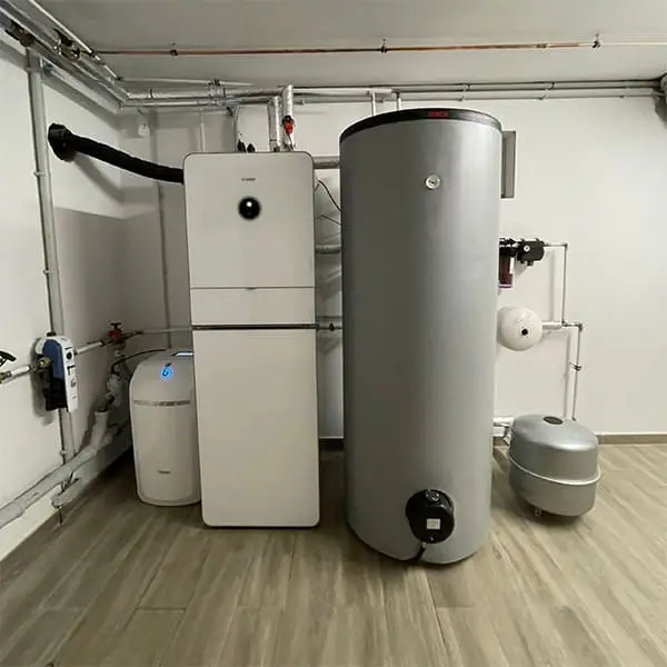 Inneneinheit und Warmwasserspeicher einer Wärmepumpen-Anlage im Technikraum